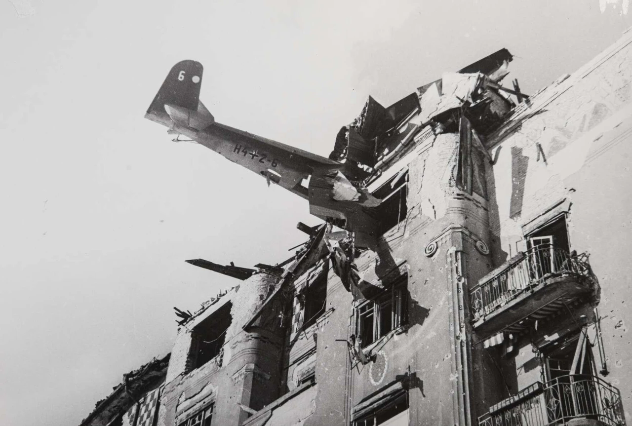 Black and white motif, an aeroplane that has crashed hanging in a destroyed building