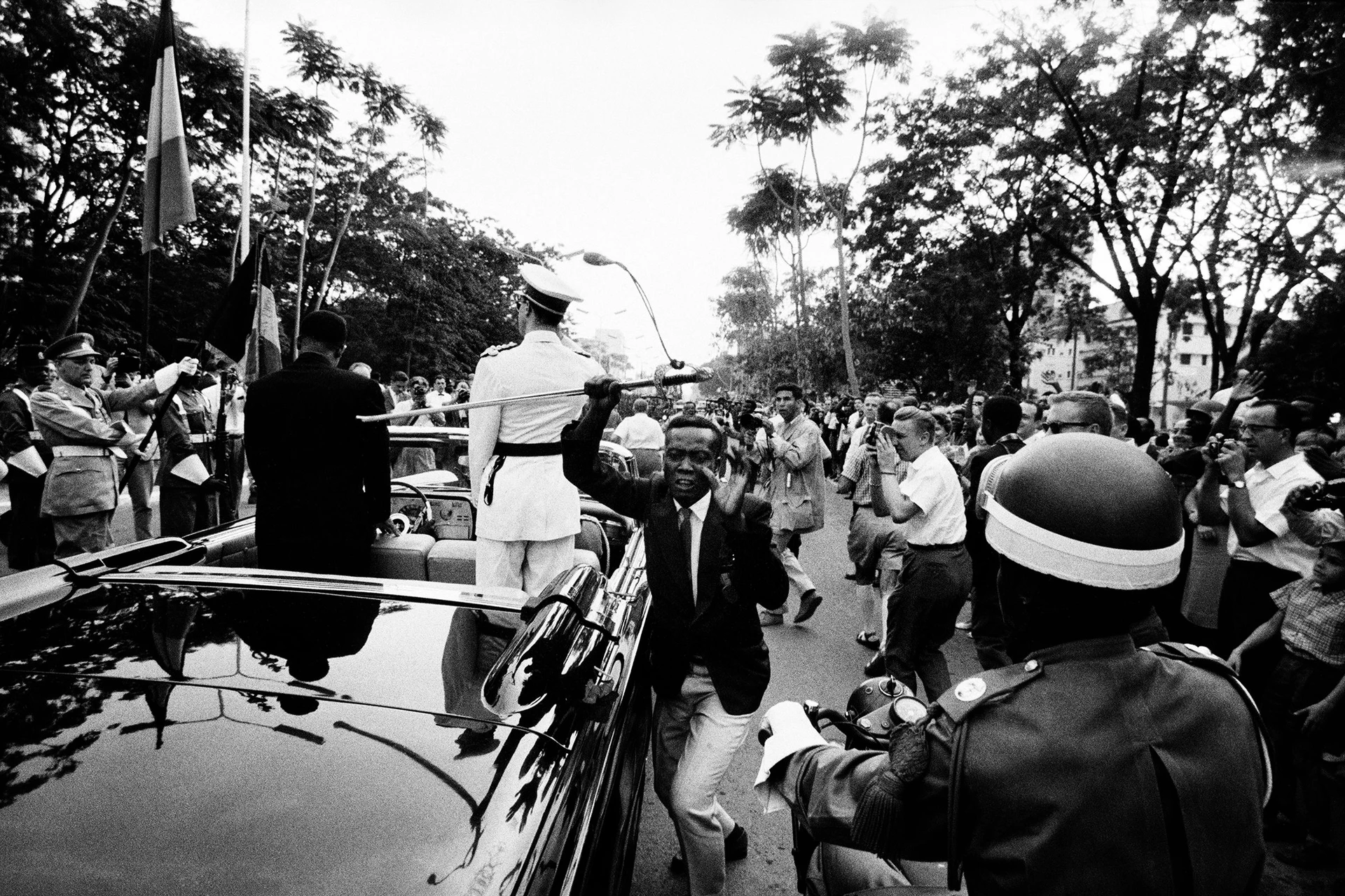 Black and white motif, man stealing a sword from a moving car