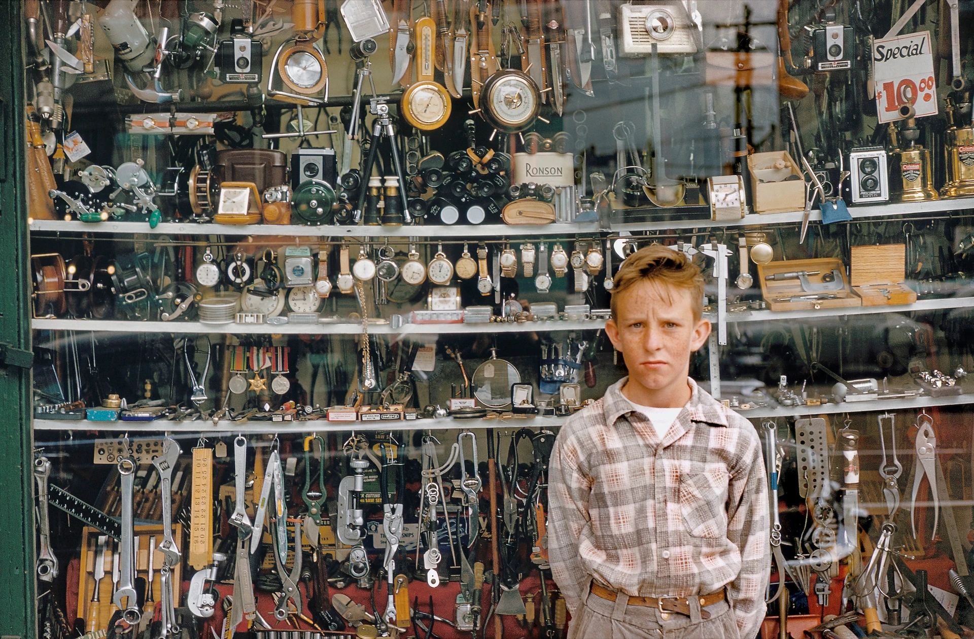 Chico delante del escaparate de una tienda de segunda mano