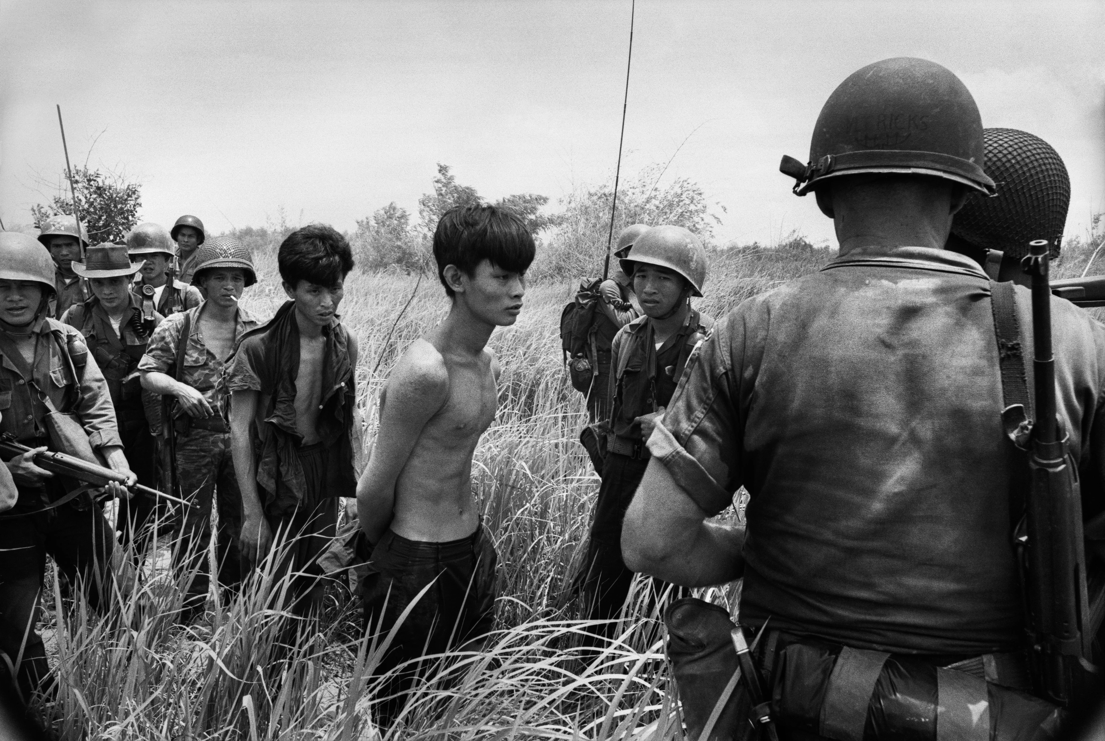 Motyw czarno-biały, wojna w Wietnamie, schwytani Wietnamczycy otoczeni przez żołnierzy na polu