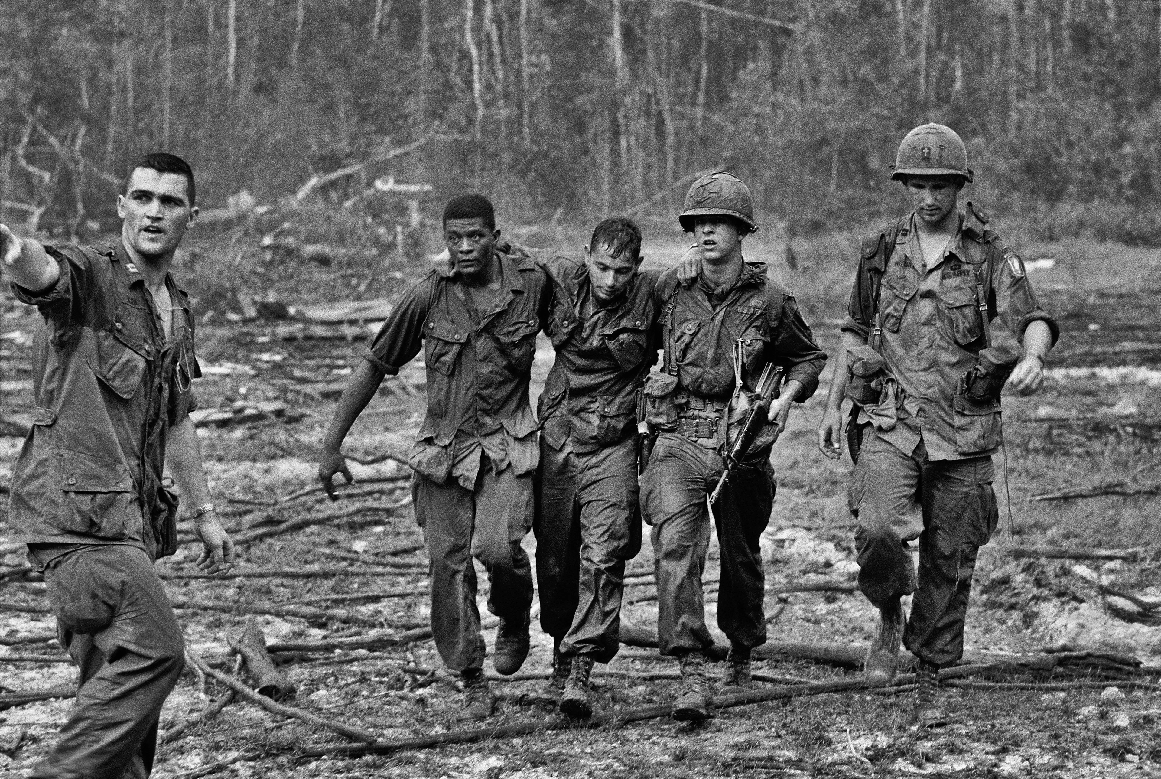 Motyw czarno-biały, wojna w Wietnamie, żołnierze podtrzymują rannego żołnierza