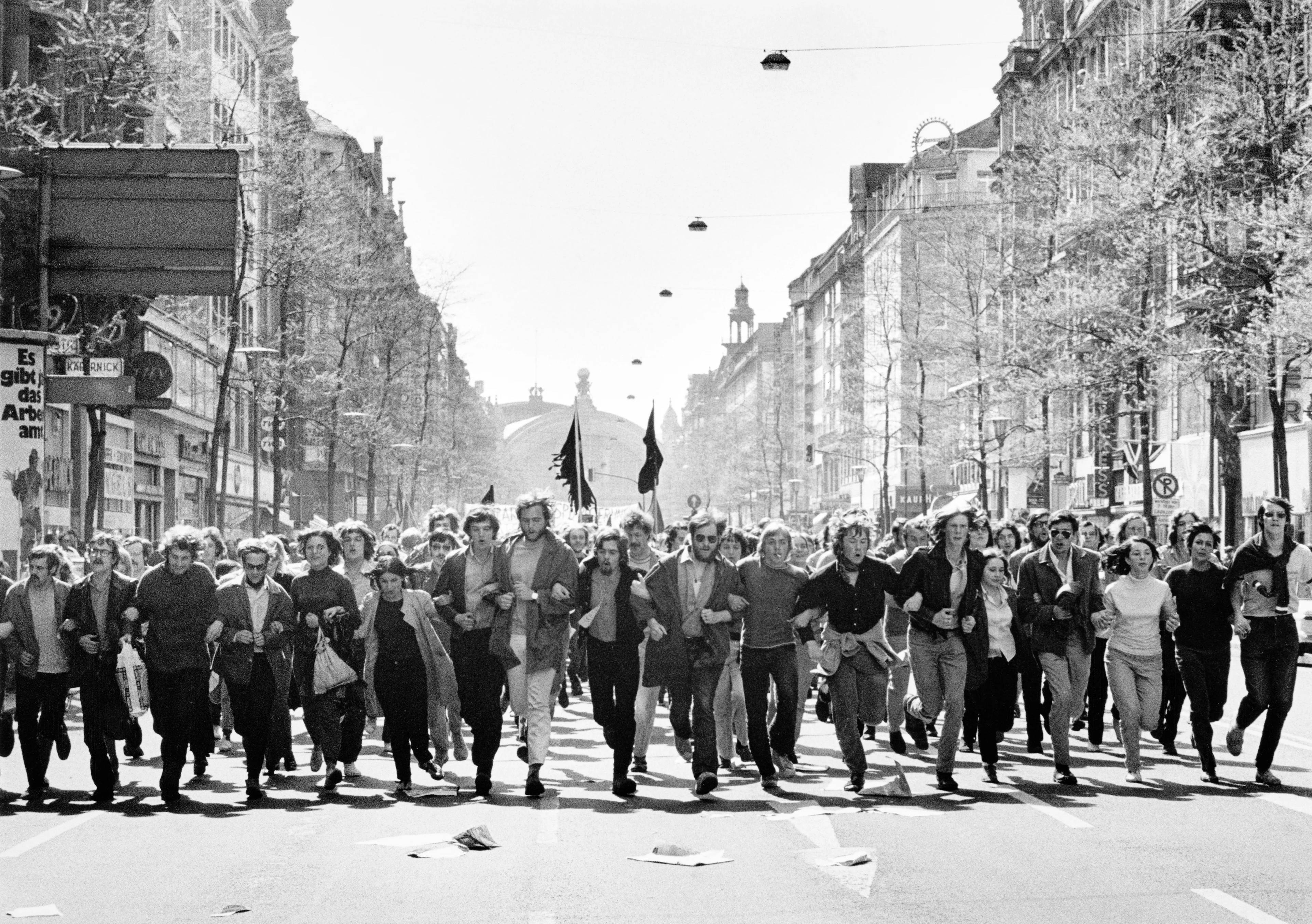 Imagen en blanco y negro, una cadena humana discurre por la calle en señal de protesta