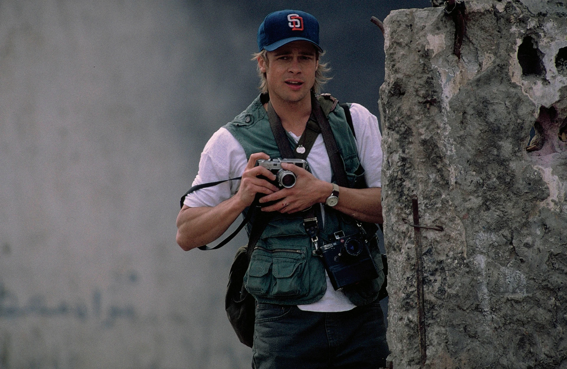 Brad Pitt czai się za murem, wyposażony w aparat Leica M6, podczas kręcenia filmu Spy Game.