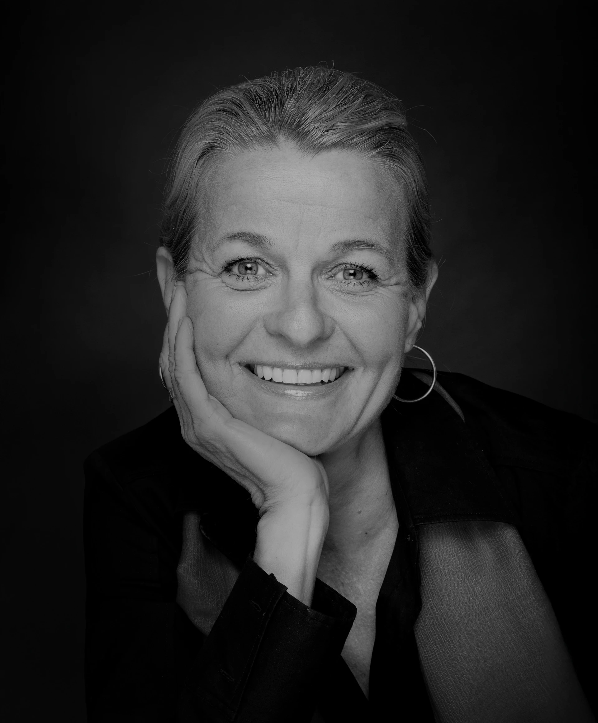 卡琳·雷恩-考夫曼女士單手托腮、對著相機微笑的黑白肖像。