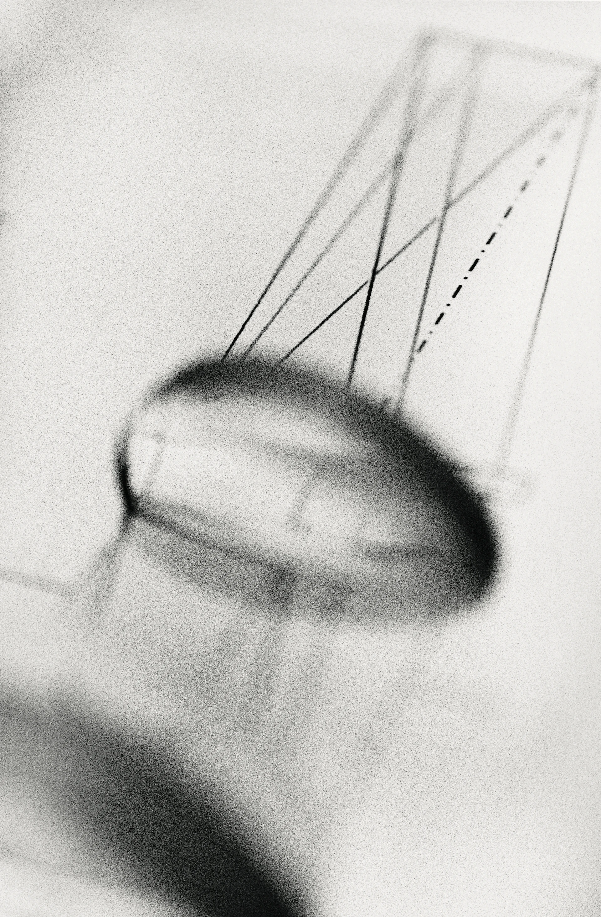 Foto astratta in bianco e nero di una lente sfocata davanti a un disegno con linee rappresentanti l’angolo di incidenza e l’angolo di riflessione.