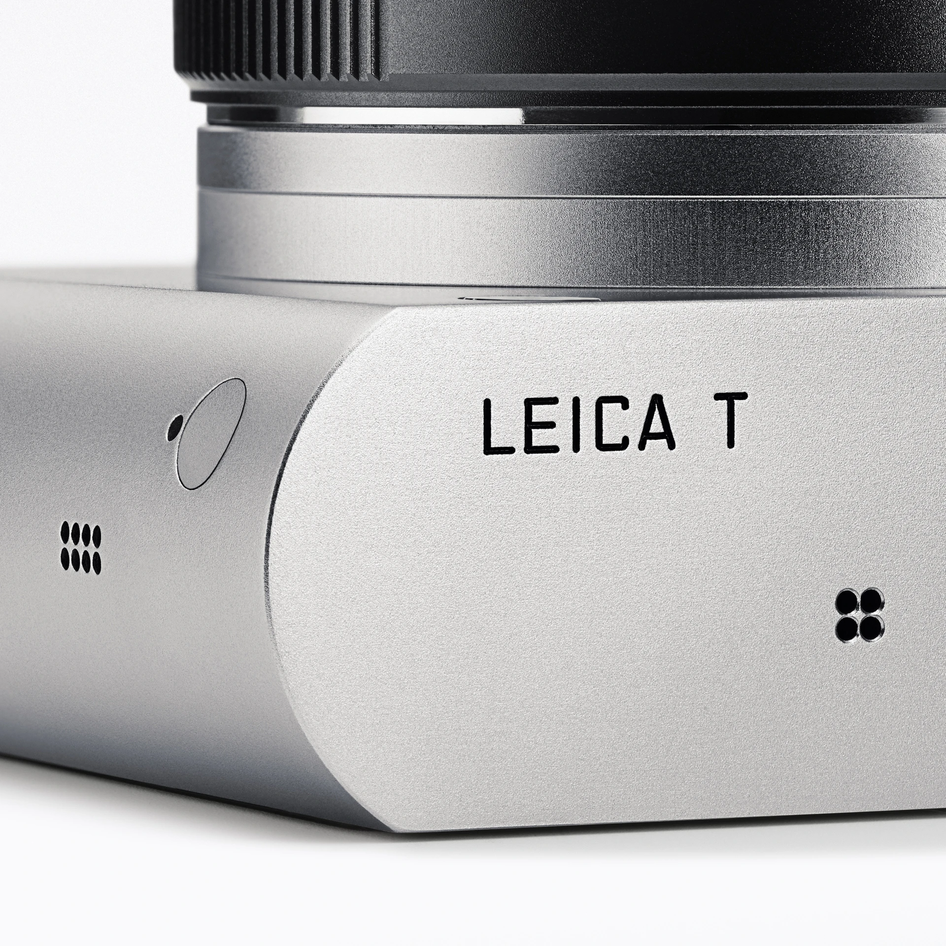 小型特写照片:徕卡T相机的侧面局部特写,展示其光滑圆润的铝合金机身、刻有“LEICA T”字样的标志以及圆形机身小开口。